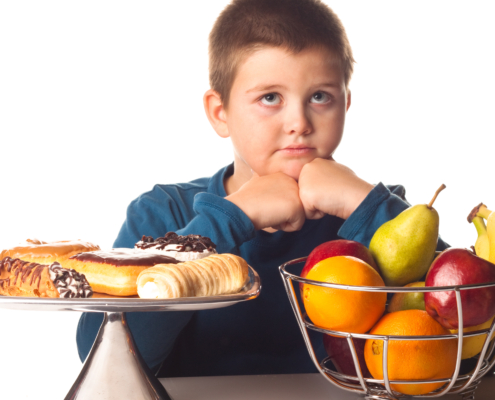 Boy Thinking Over A Healthy Snack Or A Dessert